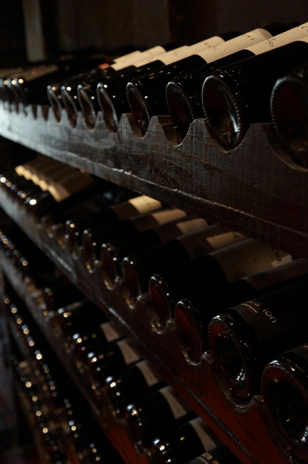 The Bosq wine cellar — rows of bottles in deep wood racks